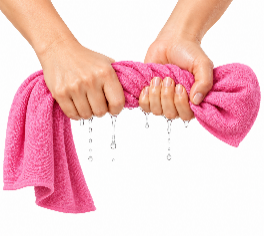 Persona absorbiendo el agua de una prenda con una toalla