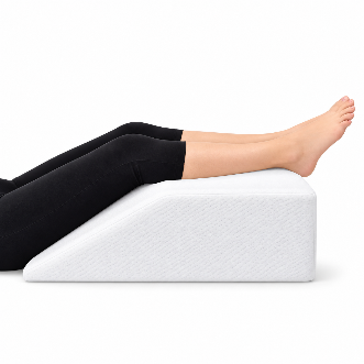 Piernas elevadas sobre una almohada antes de colocarse las medias